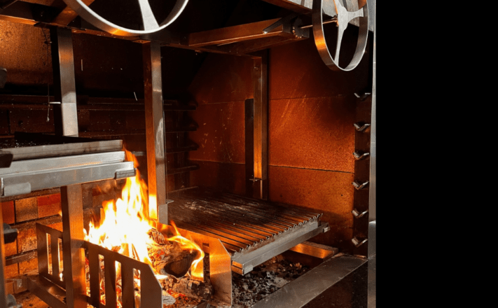 Asado Grill mit Feuerkorb im offenen Feuer und Kamin.Asado für Grillmeister und Fans von offenen Feuer